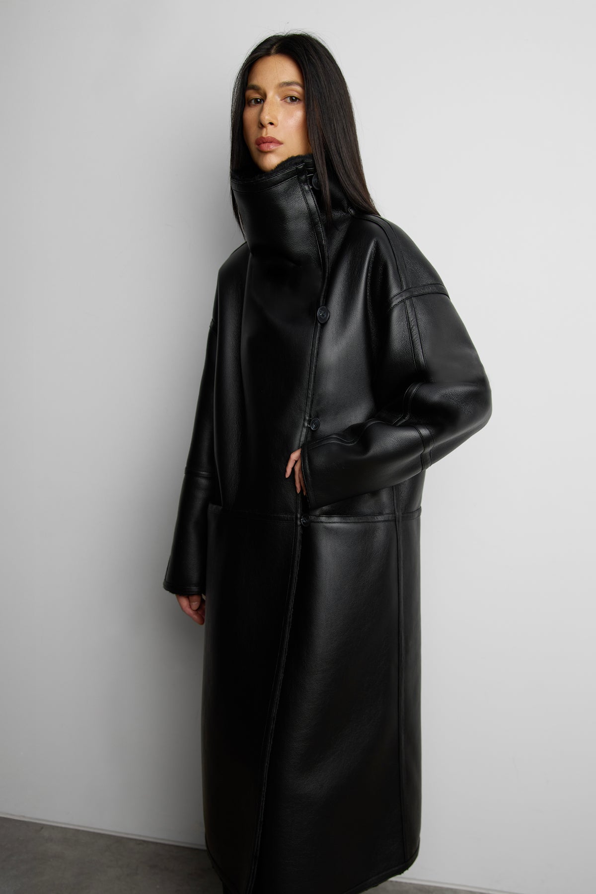 Black vegan leather coat with faux fur lining and a high funnel neck by Oak + Fort